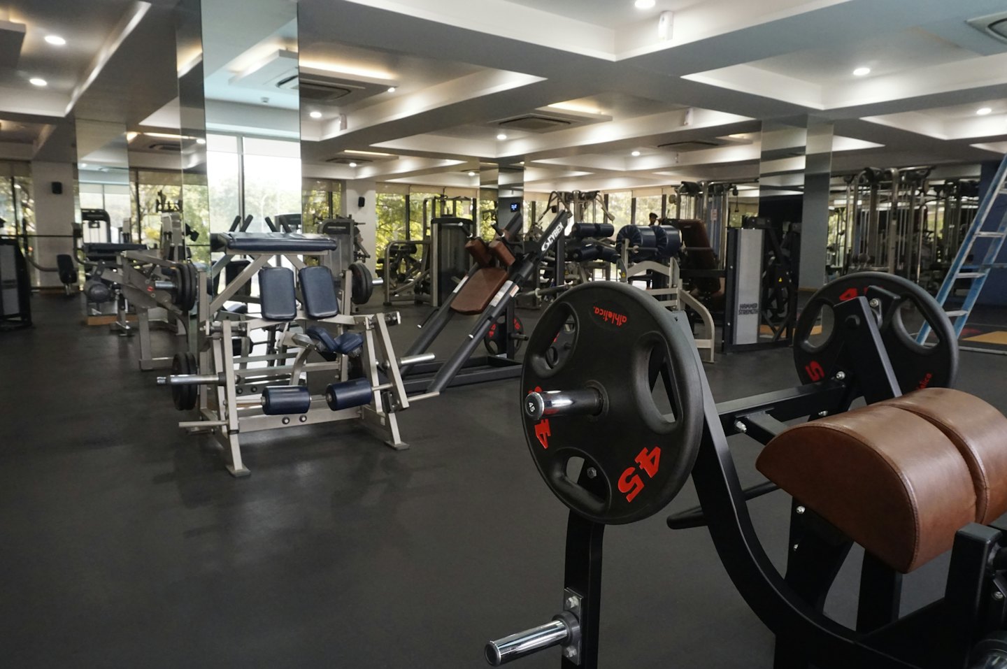 Empty, modern gym with weights and cardio machines.